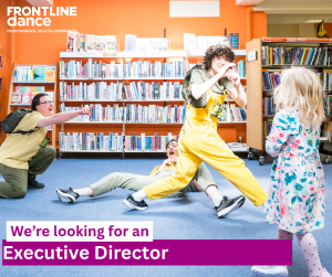 3 dancers wearing yellow performing in a library. Months open smiling or pointing a finger. Playful image. Small child can be seen joining in with her back towards the camera.